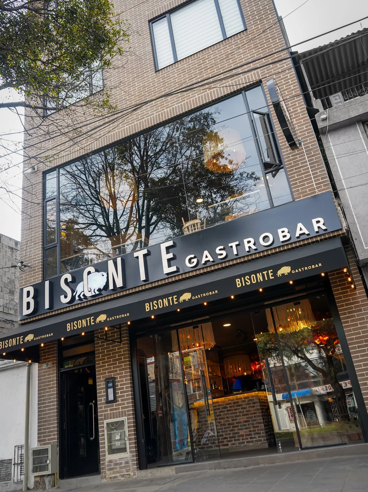 Fachada de Bisonte Gastrobar con letrero iluminado en el sur de Bogotá