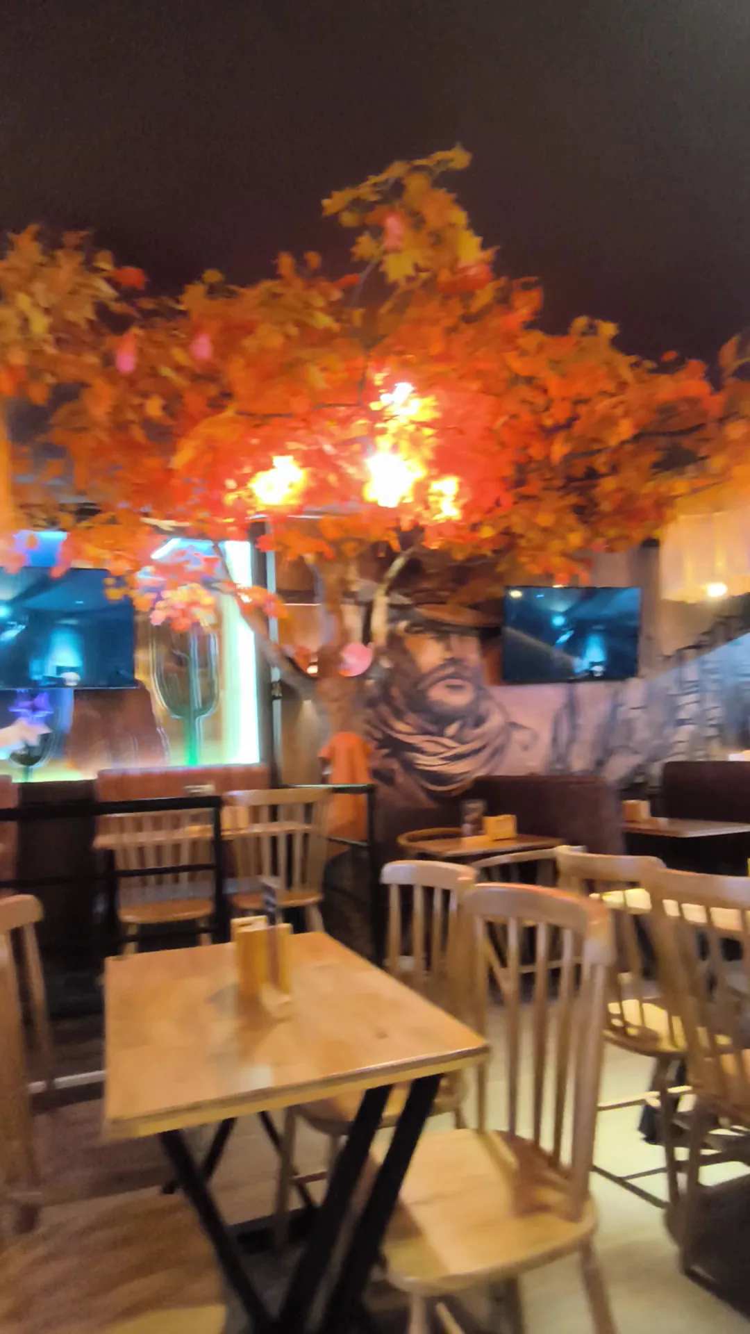 Salón rústico de Bisonte con el árbol otoñal, madera y luces cálidas